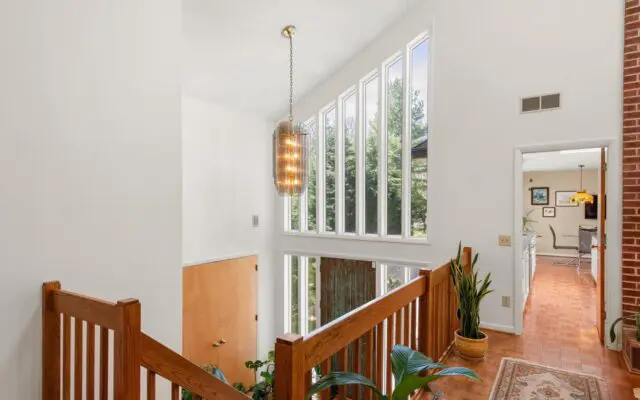 Bryn Mawr estate hallway showcasing a decorative brick wall and a classic wooden staircase 