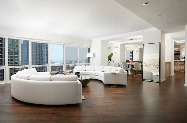Spacious living room with curved couch, scenic view window (One Hundred East Huron, Chicago) 