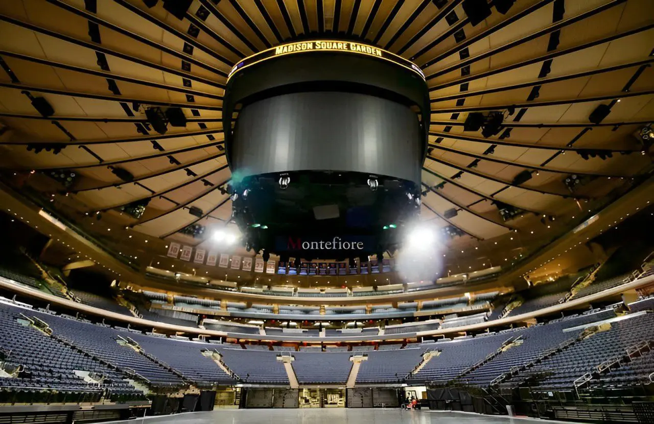 Interior of a sports arena with a large, circular structure hung from the roof