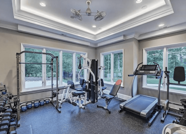 Inside Christian McCaffrey's Mansion on Lake Norman in North Carolina 16 Home Gym with treadmill and windows to a woods