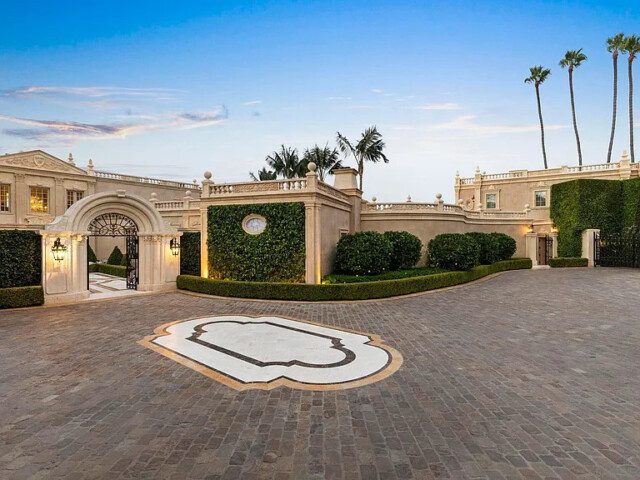 Gated driveway leading to the entrance of a luxury California mansion