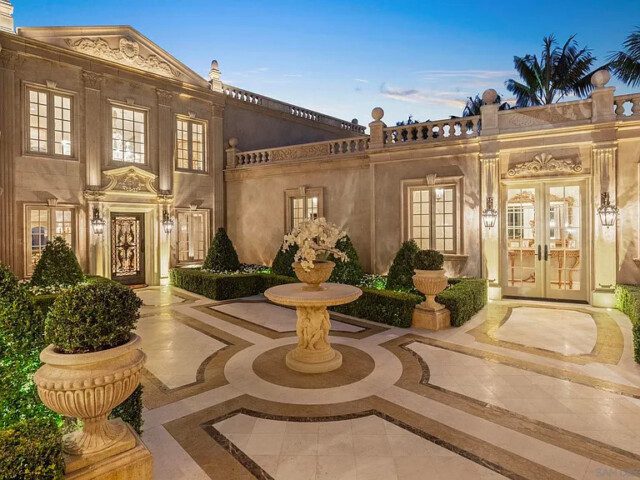 Ornate entrance with elegant columns and glass accents on a lavish estate