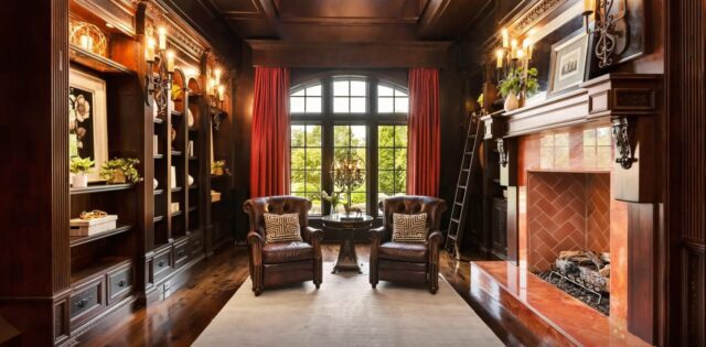 Home library with bookshelves and a fireplace in a Waxhaw estate