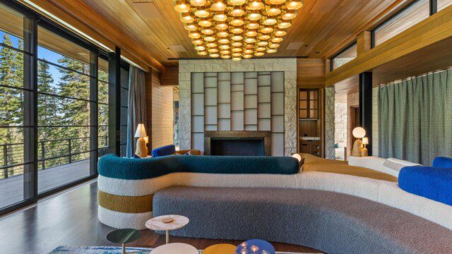 Upscale living room with modern light fixtures and large windows in Russell Weiner’s former house. 